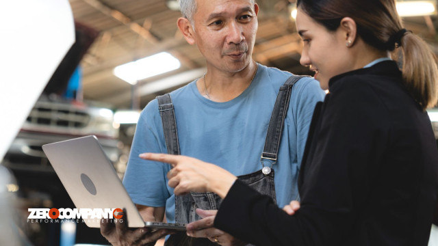 senior male mechanic and woman in uniform checking a laptop