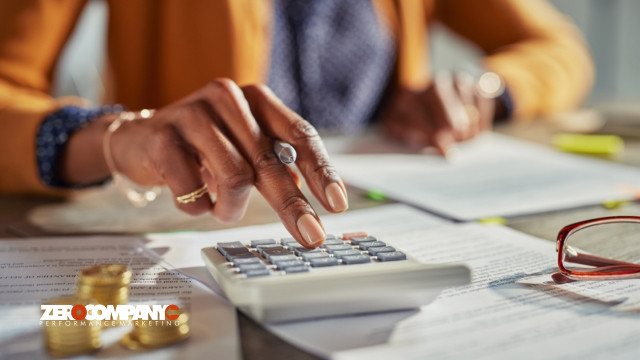 Casual businesswoman using calculator to check monthly income and expenses
