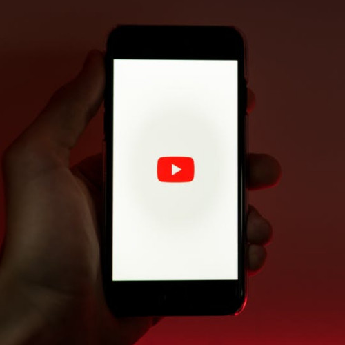 man holding cellphone with youtube app