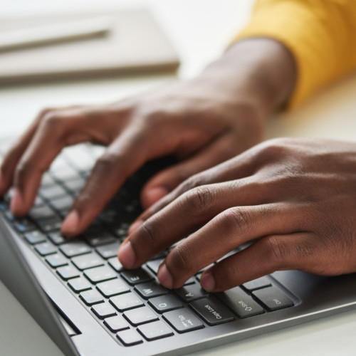 student typing on laptop keyboard