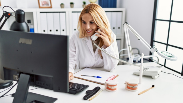 dentist using a computer and talking on the phone