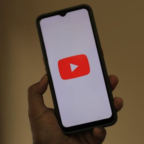 person holding black iphone with Youtube logo on the screen