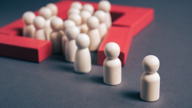 Conceptual image of a group enclosed within a red boundary while others remain outside